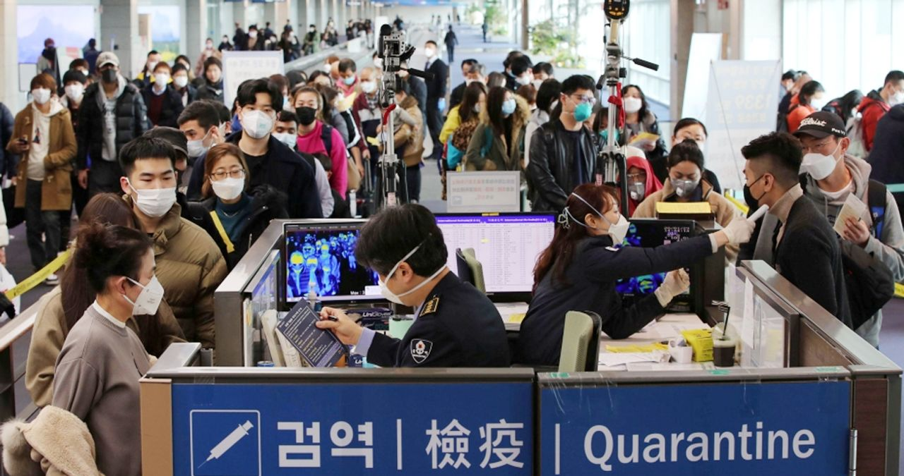 韓國機場檢疫區排滿了戴口罩的旅客，來反映疫情下的入境檢查措施。