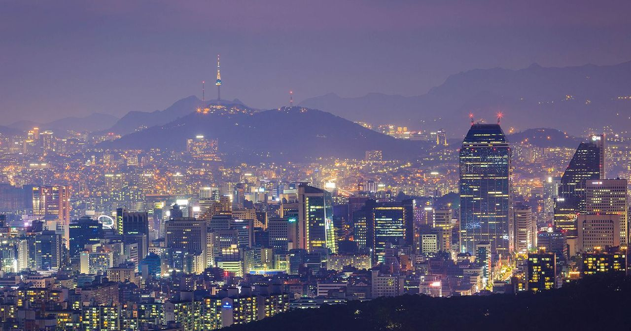 韓國首爾市中心夜景，展示著高樓大廈和南山塔，是房地產新聞的背景