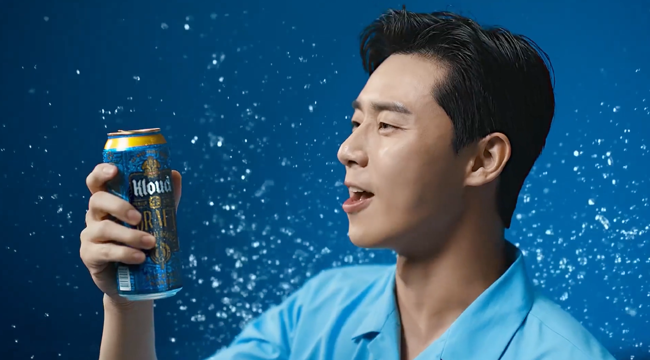 手持Kloud生DRAFT啤酒罐，在水珠背景下展示啤酒的清爽感