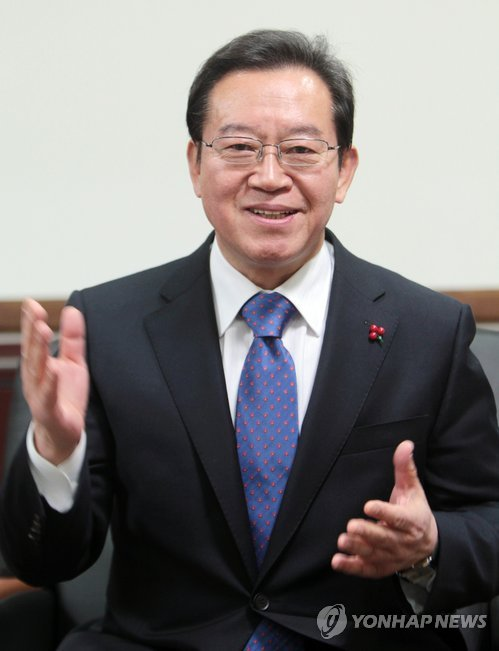 ภาพถ่ายชายใส่สูทและเนคไท กำลังมีการประชุมเกี่ยวกับการจ้างงานแรงงานต่างชาติในประเทศเกาหลีใต้เพื่อแก้ไขปัญหาการขาดแคลนแรงงาน