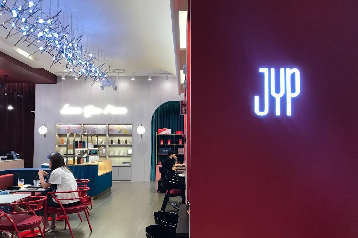 JYP SOULCUP Cafe 內部飾有JYP相關燈箱標示，展現品牌風格