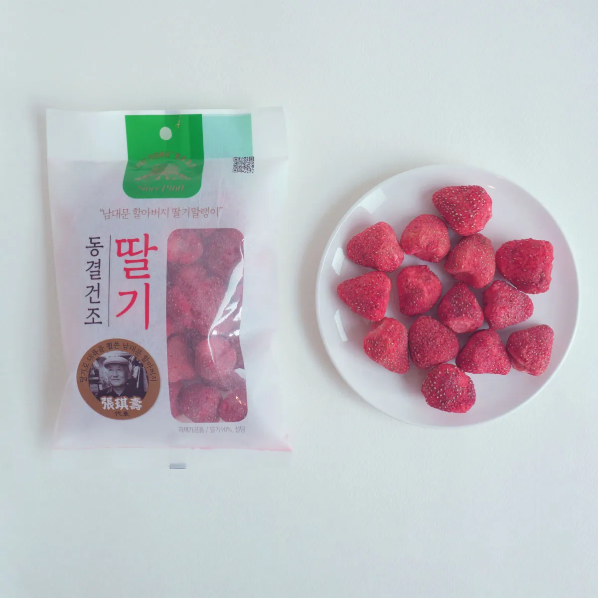 南大門老爺爺的乾燥草莓產品，展示在白色盤子上。巧妙的包裝設計突顯了草莓乾脆而香甜的特點。