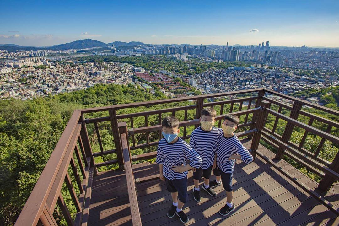 三胞胎在南山觀景台上背對景觀，享受户外的清新空氣和美景。