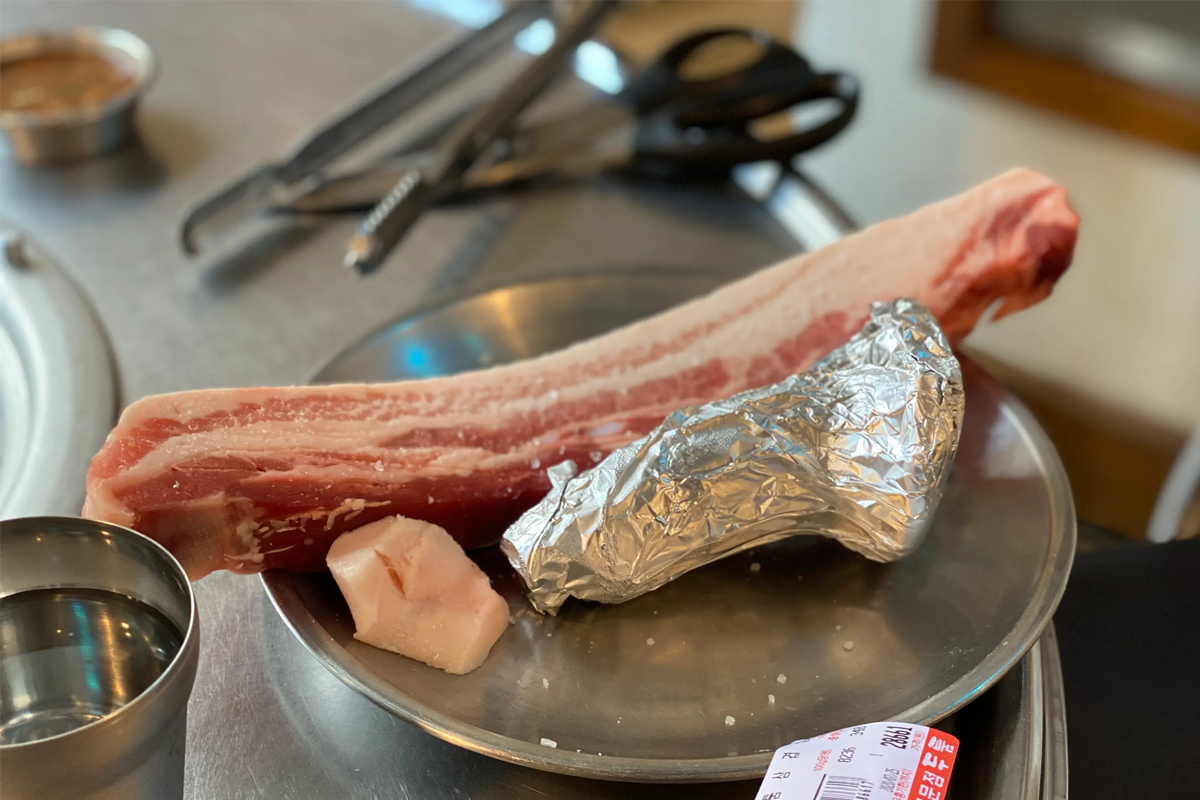 首爾的烤肉店『厚肉』裡，生的三層肉準備登場