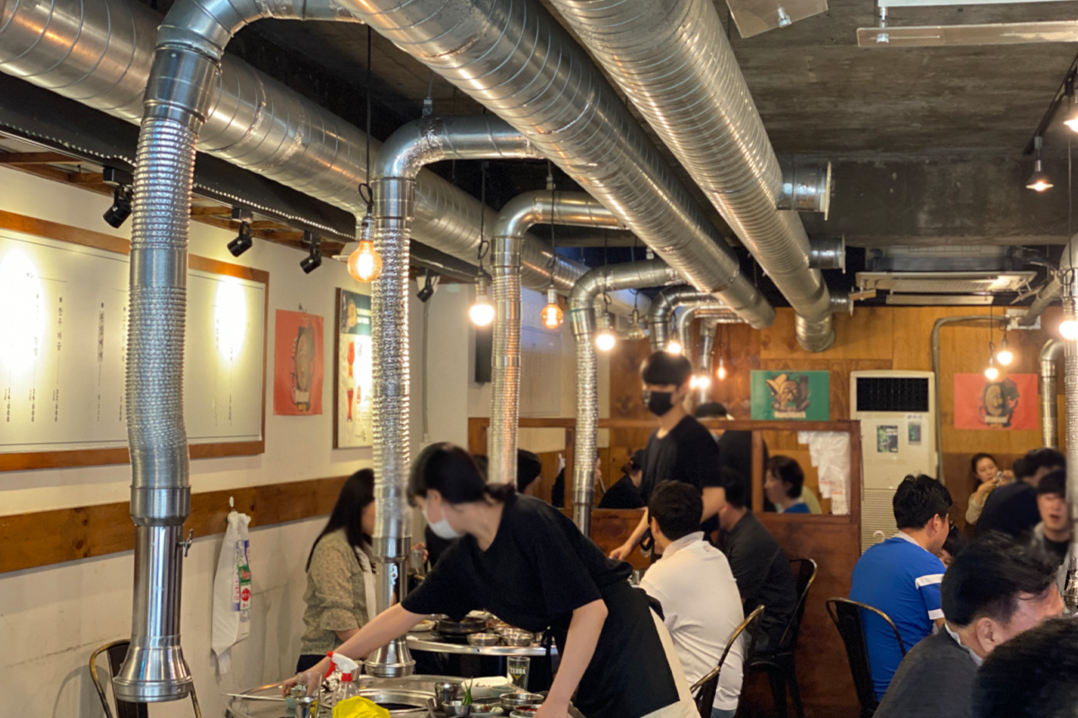 韓國首爾一間燒肉店內的環境，裝飾著通風管和各種照明燈。