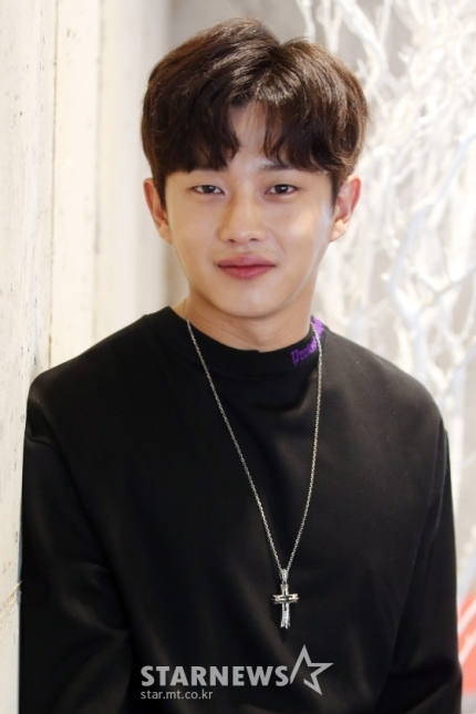 身穿黑衣男子坐在椅子上，展現金玟錫休閒的一面