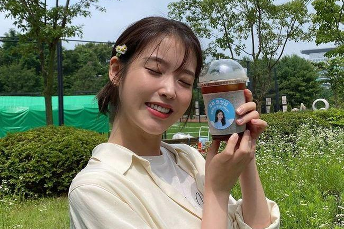 一個人手持外帶咖啡，象徵著韓國常見的社交飲品習慣。