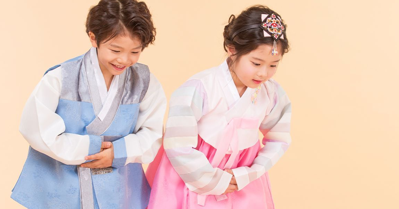 兩個小孩穿著韓國傳統服飾，可能正在慶祝重要的傳統節日。