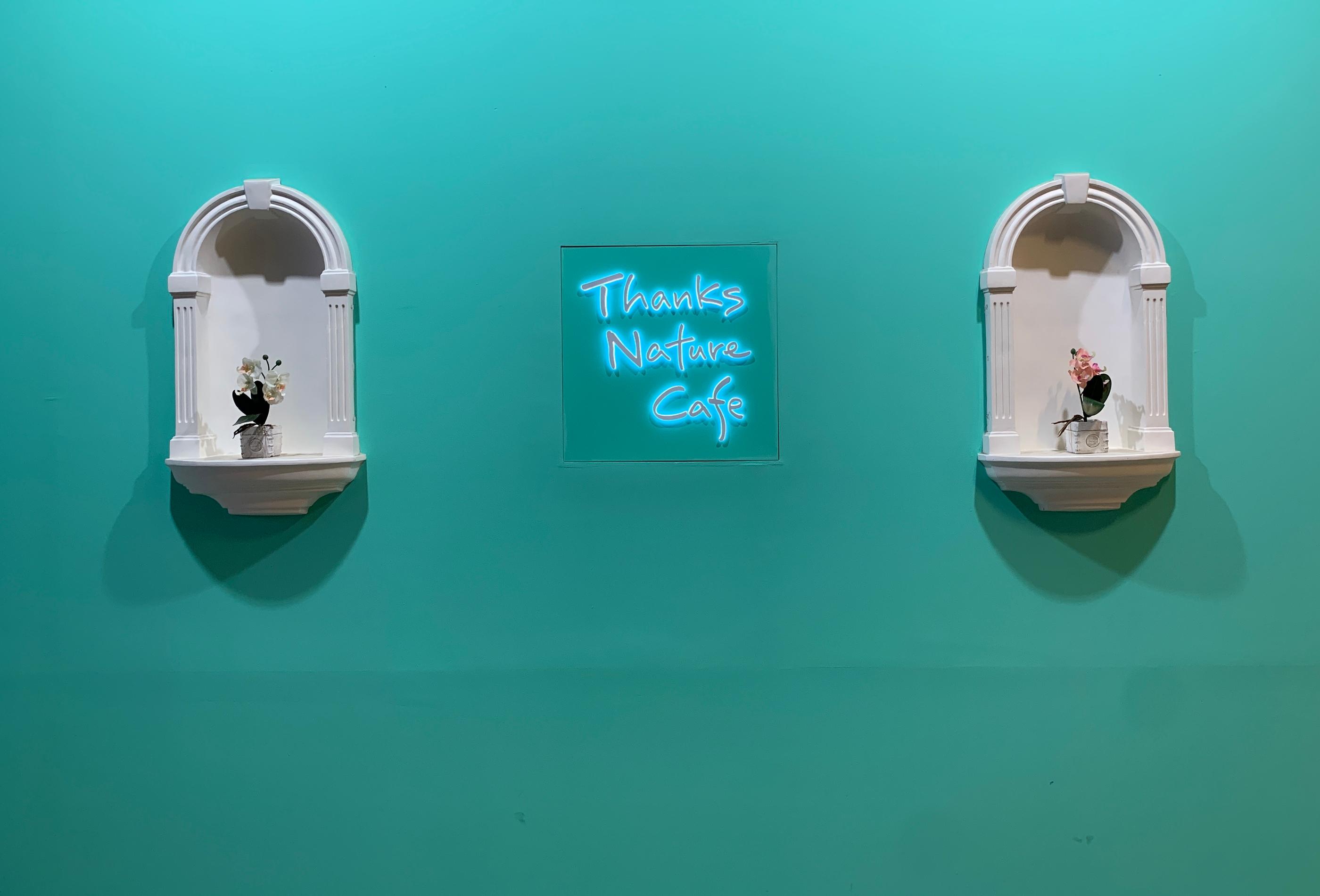 壁に飾られたネオンの「Thanks Nature Cafe」のロゴ