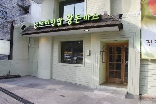 Một bữa ăn tại Namsangol Sanchaejip, nổi bật với miếng tonkatsu lớn và món kim chi.