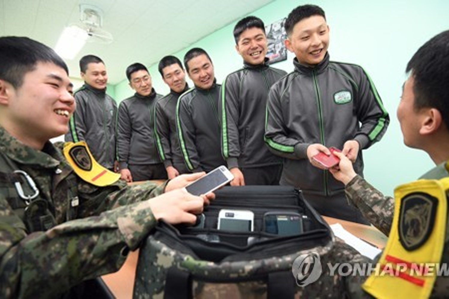 韓國軍人正在驗收士兵們的手機，強調軍隊中的紀律管理。