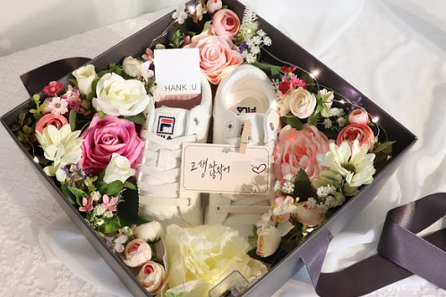 一對放置於美麗花朵中間的運動鞋，象徵著韓國男朋友退役送給女友的『花鞋』禮物。