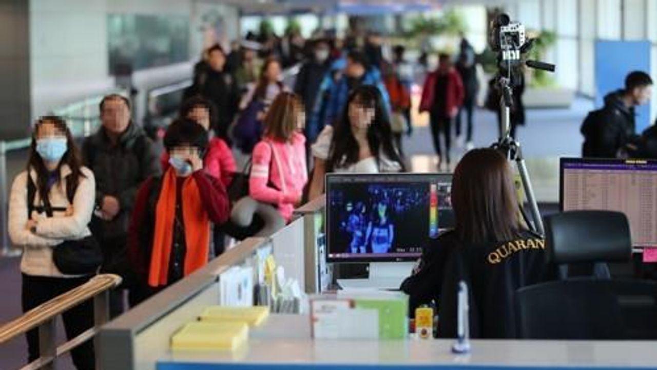 ผู้โดยสารใส่หน้ากากขณะได้รับการตรวจคัดกรองที่สนามบินในเกาหลีใต้ เพื่อตรวจจับอาการโควิด-19