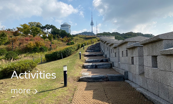 Pathway to Namsan Seoul Tower at Namsan Park in Seoul, surrounded by lush greenery and historical walls.