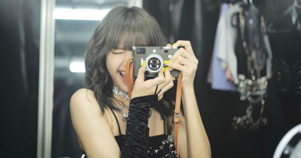 手持經典膠捲相機的模特，專注鏡頭的拍攝動作。