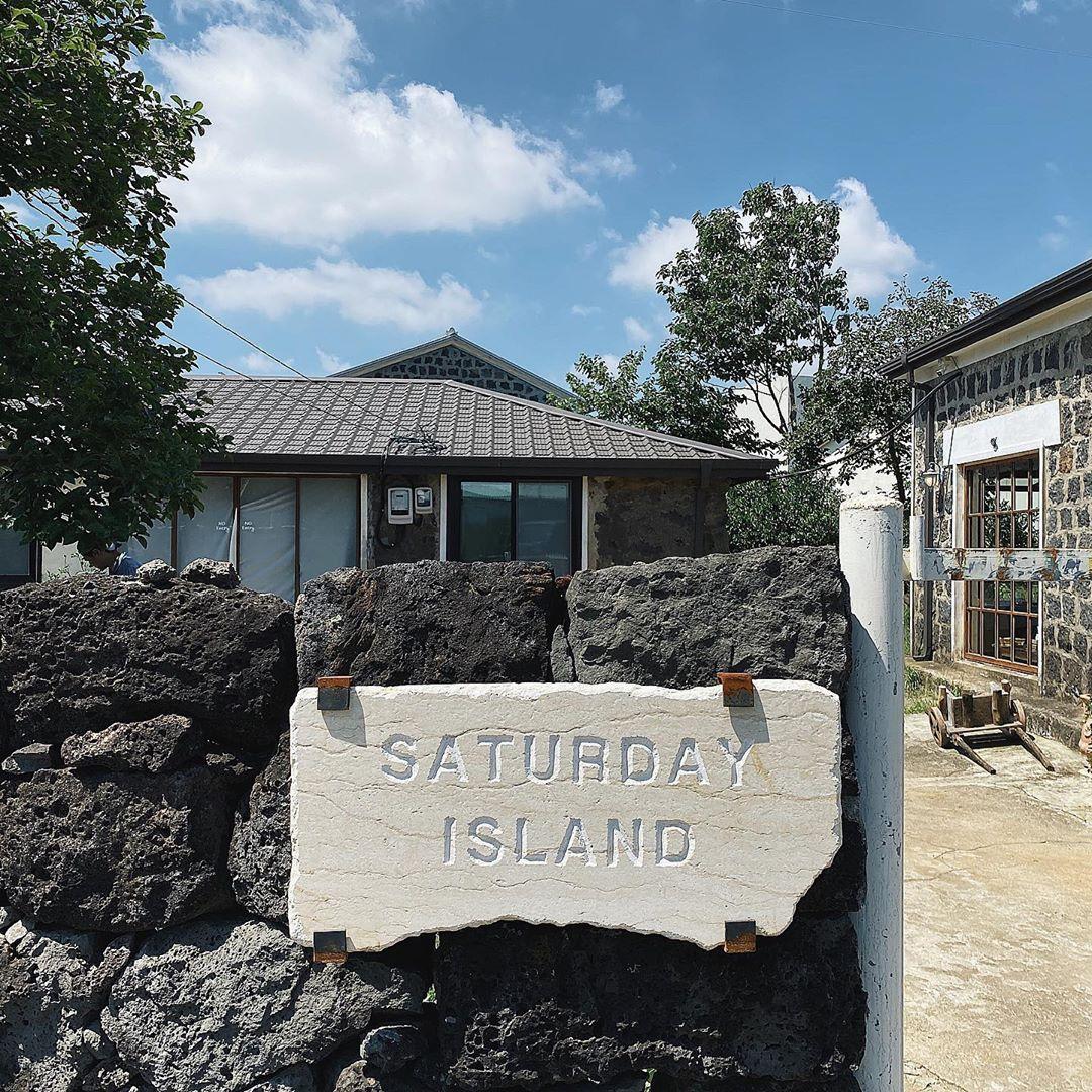 サタデイアイランドカフェの木製のテーブルにクロワッサンと飲み物が並ぶ写真。カフェのシンプルで温かさを感じるインテリア。