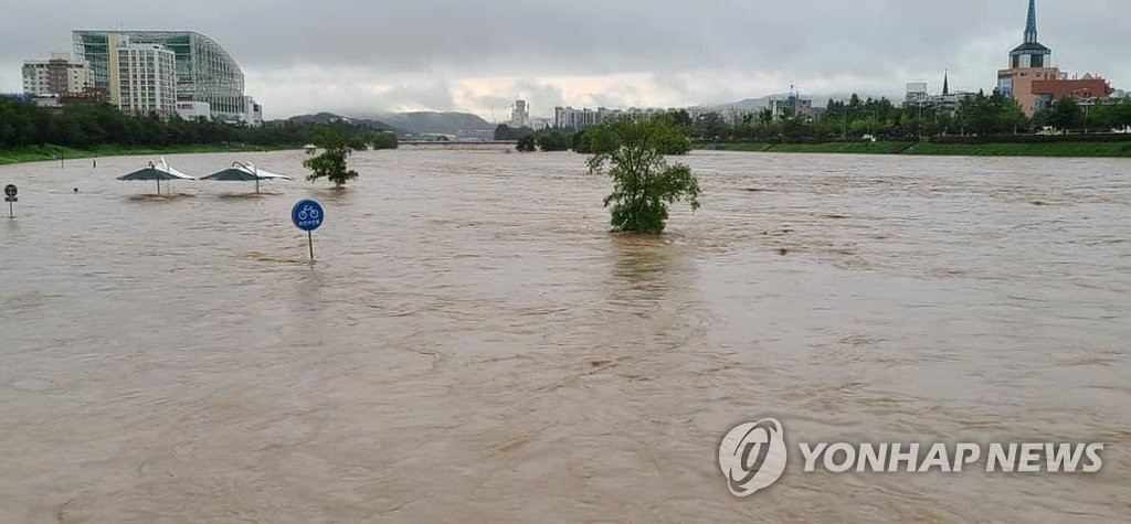 受豪雨影響，河流水位猛漲，周遭的自行車道和指示牌被完全淹沒。