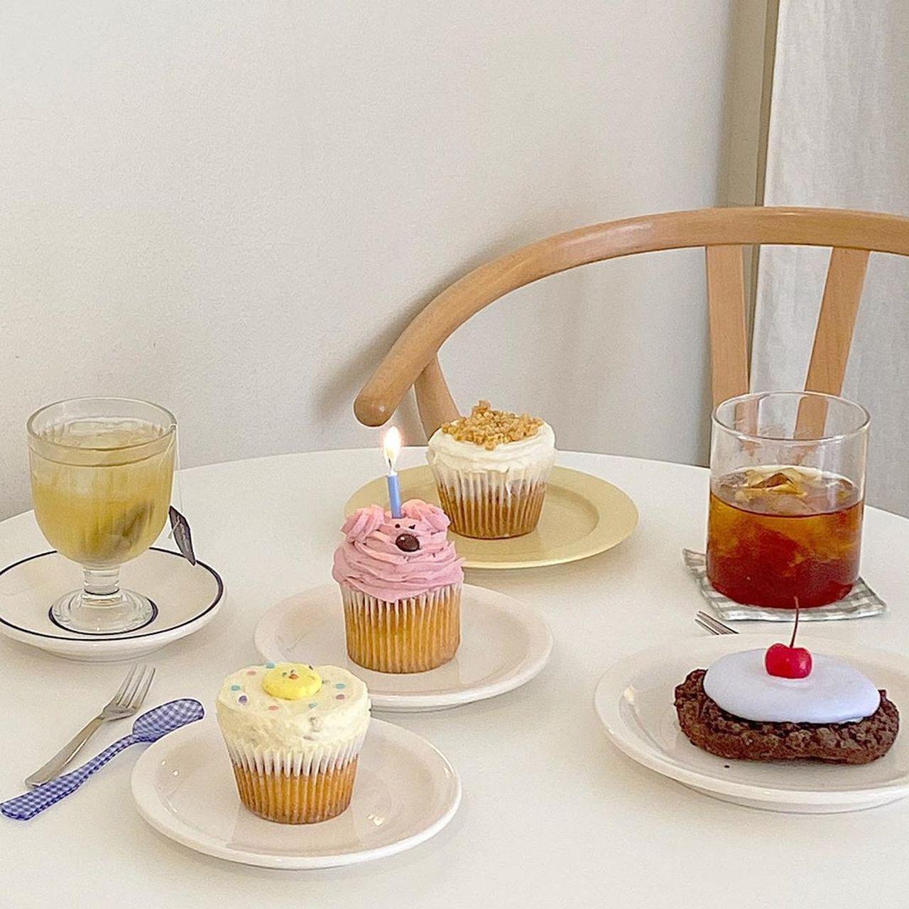 ヨンナムドングラミカフェで提供される色とりどりのカップケーキとドリンク。可愛らしいデザインと豊かな味わいが評判。