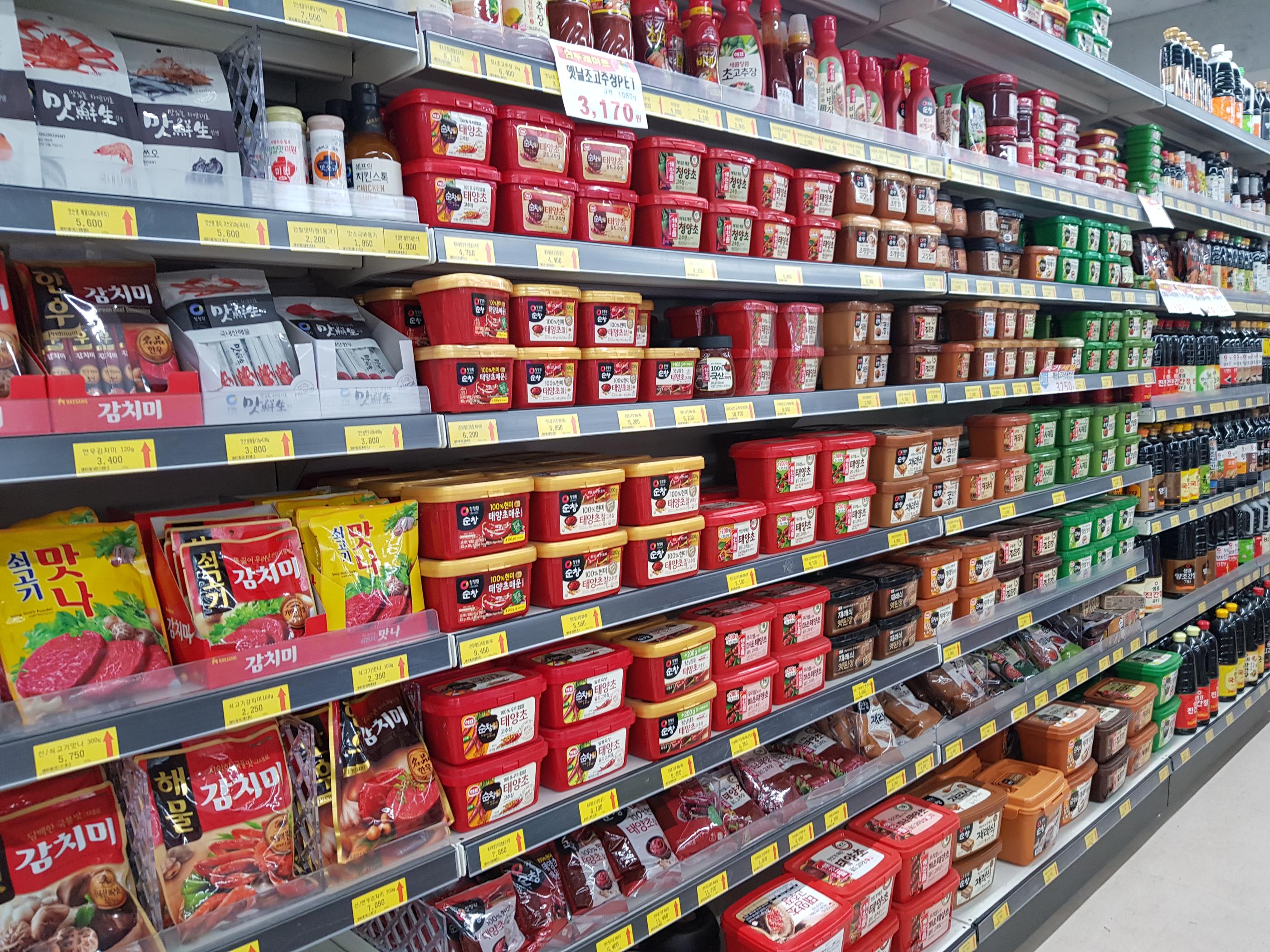 韓國超市的調味料貨架，種類繁多，滿足各種韓國料理的需求，是家庭備餐的利器。