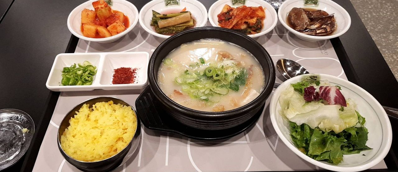 豐富的韓國餐桌，擺放著米飯、湯、泡菜及多樣的韓國小菜，呈現韓國家庭日常傳統美食的樣貌。