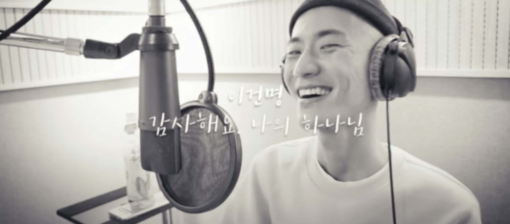 在錄音室中的一名男子唱歌,旁邊有麥克風和耳機