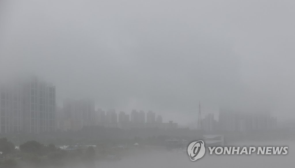 首爾在豪雨下的城市天際線,建築物幾乎被厚厚的雨霧遮蔽。