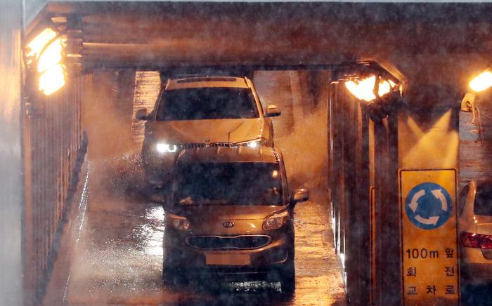 ソウルの光化門中央地下歩車道に雨水が溜まり、車が徐行する様子。強い雨でバリアアゲを探求する観光客の動きが制限されている。京郷新聞撮影。