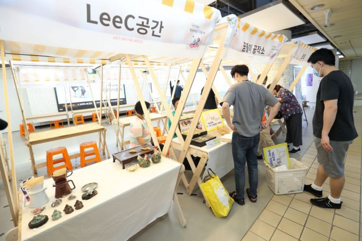 LeeC空間的傳統市場裡,攤主展示和出售手工藝品及雜貨,呈現市場活力。