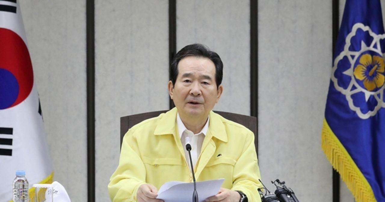 ภาพการประชุมเกี่ยวกับสถานการณ์โควิด-19 ในเกาหลีใต้, ผู้แทนรัฐบาลกำลังพูดในระหว่างการประชุมในห้องที่มีธงประเทศเกาหลีใต้และตราองค์กร