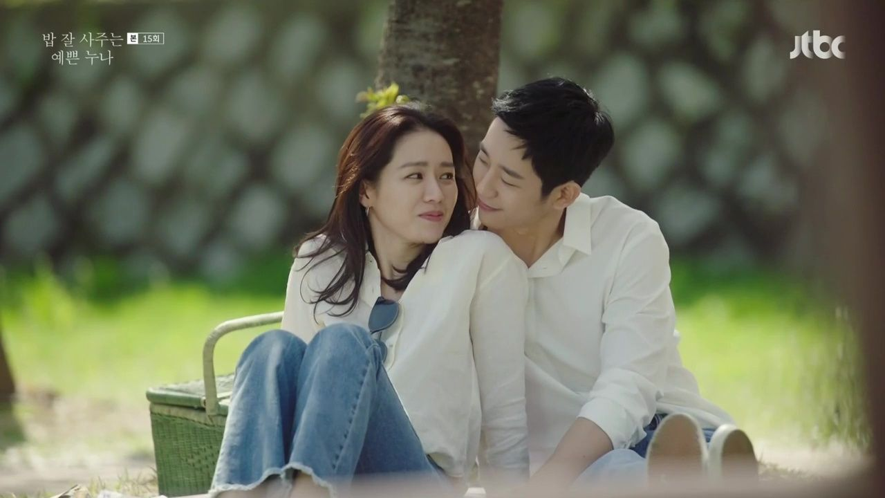 Noona Romance Hàn Quốc: Một cặp đôi trẻ trung ngồi cạnh nhau dưới tán cây, thể hiện sự gần gũi và lãng mạn đặc trưng trong phim truyền hình Hàn Quốc