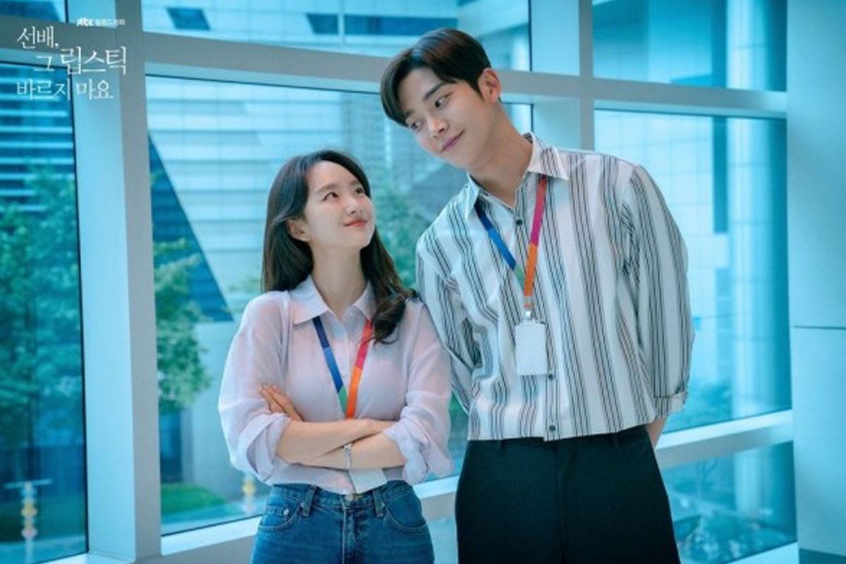 ชายหญิงยืนใกล้กันริมหน้าต่างในออฟฟิศ สื่อถึงความสัมพันธ์สบายๆ และโรแมนติกในที่ทำงาน