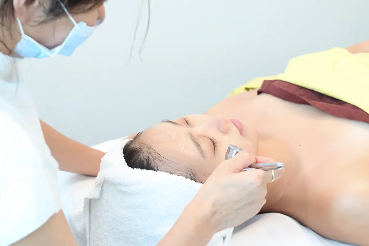 Shin Jiyoon皮膚管理中心,美容師正在進行面部護理療程。