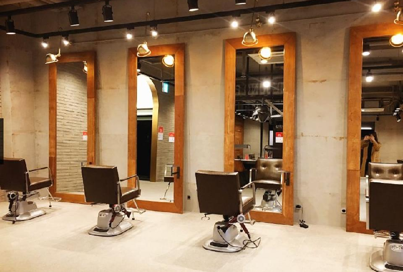 複数のミラーと椅子が並んでいる韓国の美容室内部。