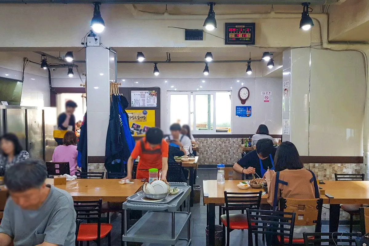 Busy interior of Daesung Galbi, known for authentic charcoal-grilled pork ribs, with diners enjoying meals in Seongsu.