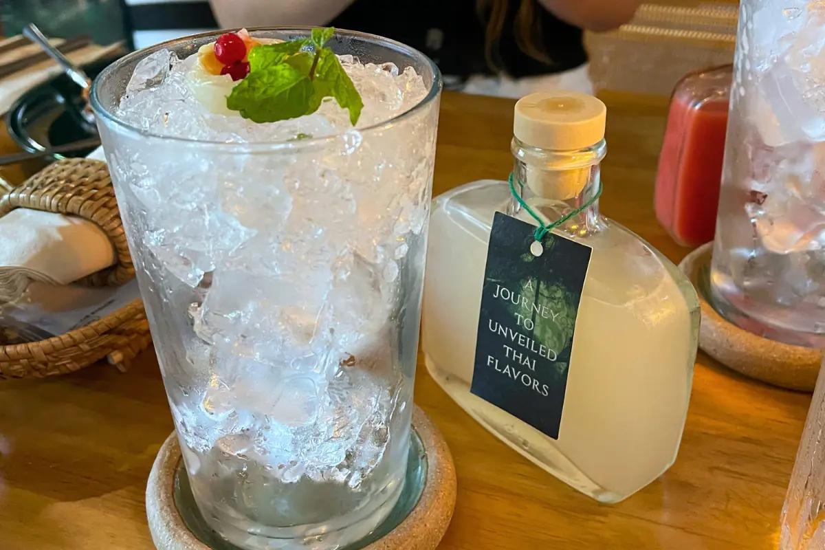 Refreshing Mangosteen Juice served in a cute bottle at Saladaeng Temple, adding an exotic touch to the Thai-inspired meal.