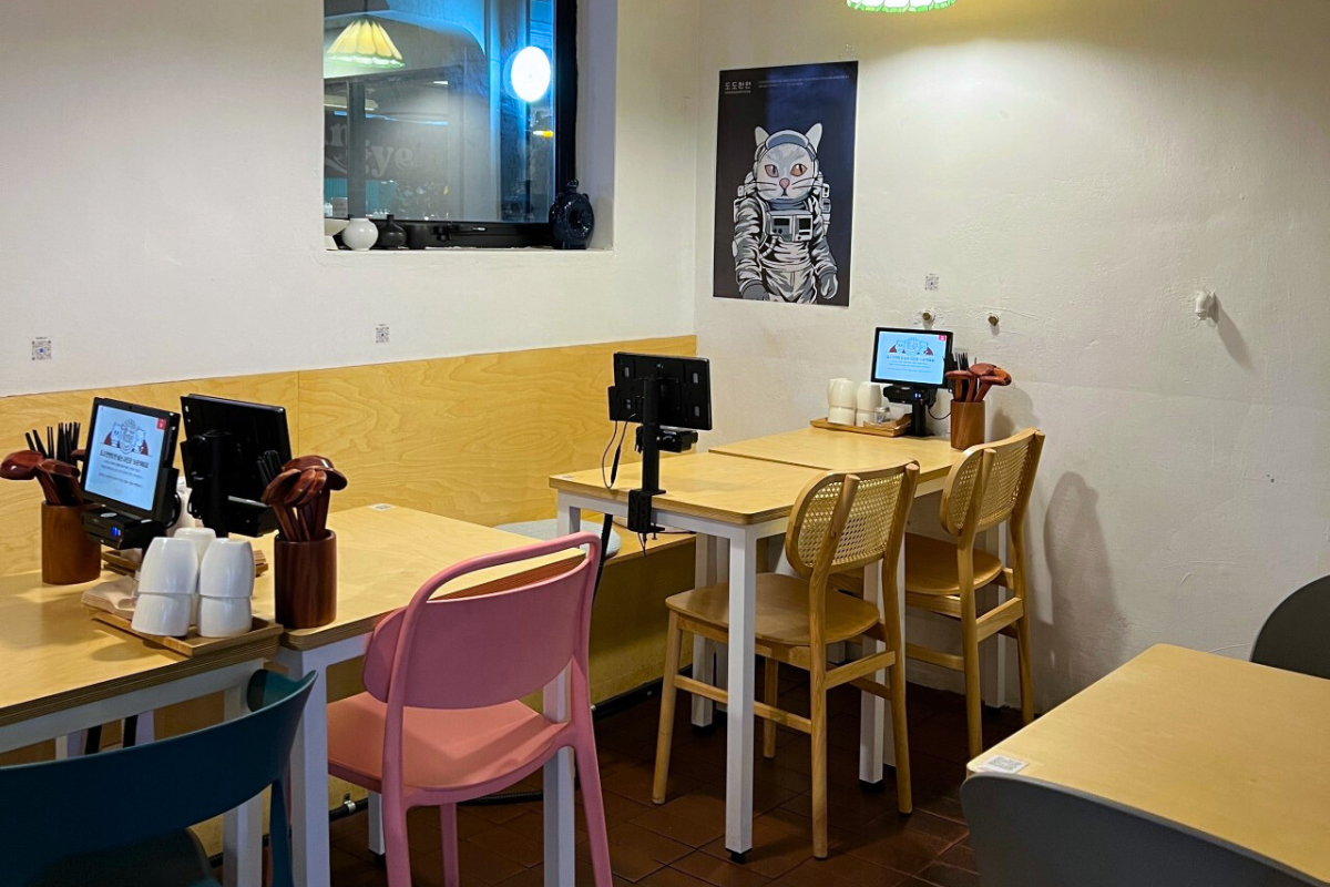 Dodohanmyeon's modern and minimalist interior with tech-savvy tablet ordering system on tables in Seongsu.
