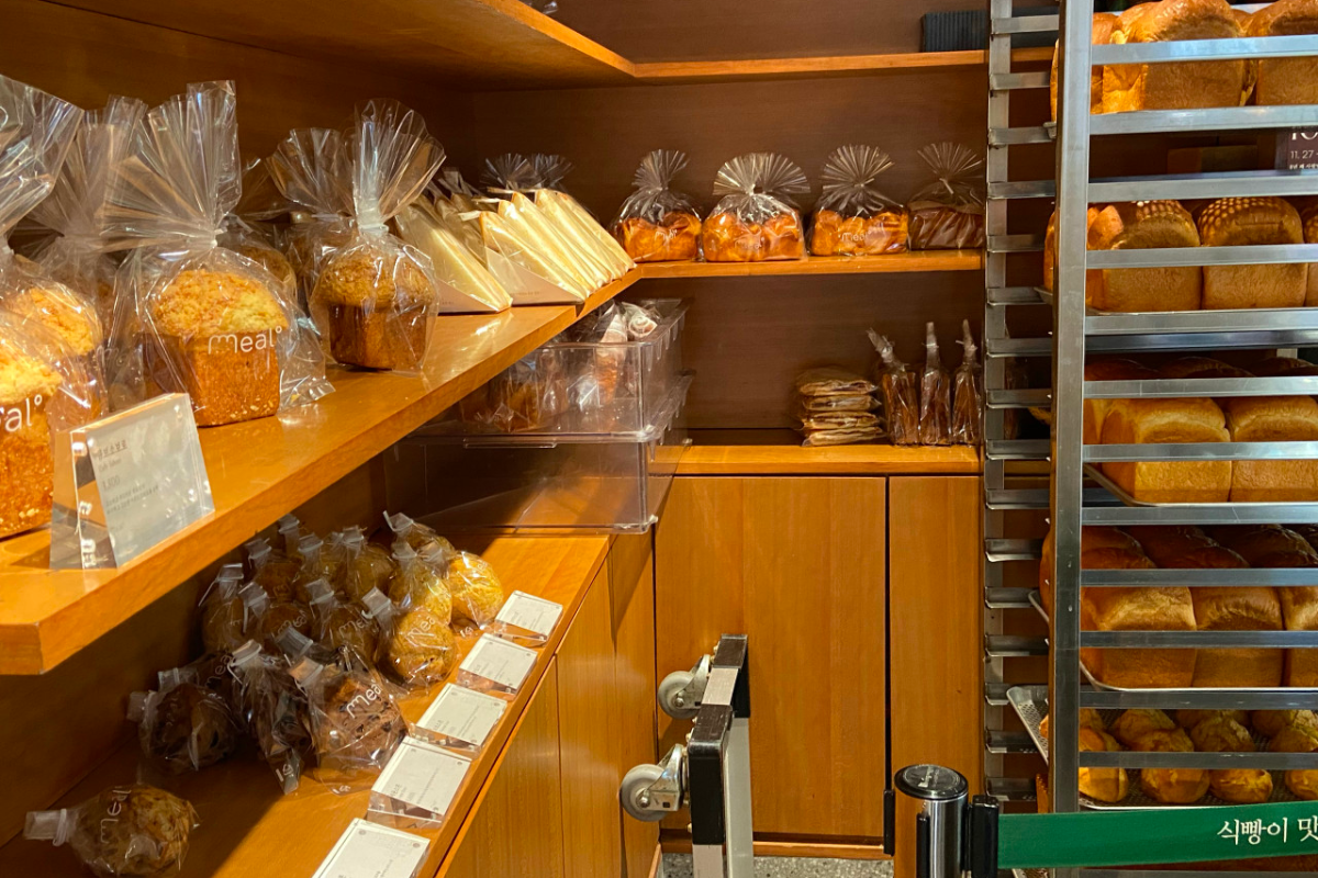Interior shelf at Meal Bakery in Seongsu, Seoul, displaying an assortment of freshly baked loaves and pastries.