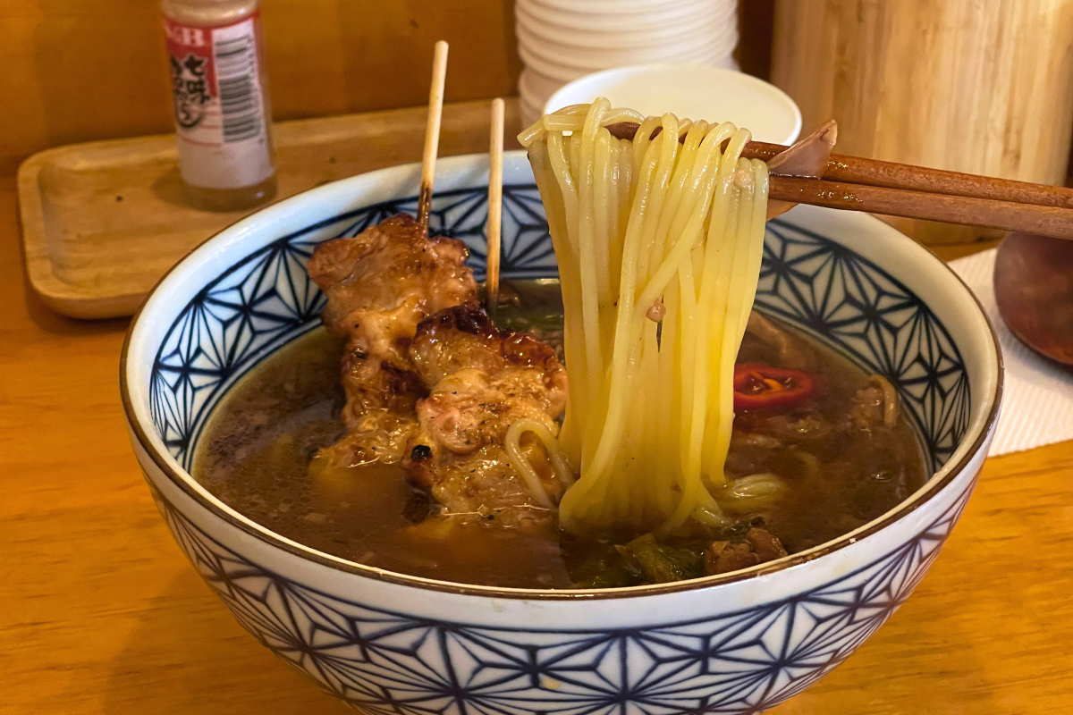 A bowl of Onmyeon with chicken skewers at Daerim Guksu, a popular restaurant for rich noodle soups in Seongsu.