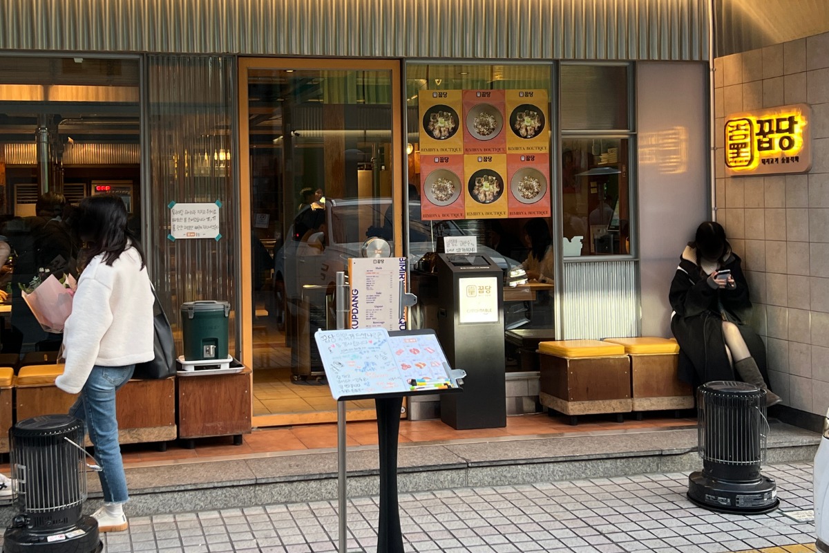 Front entrance of Kkubdang, a Michelin-rated Korean BBQ restaurant in Seongsu, with a modern exterior and glass panels.