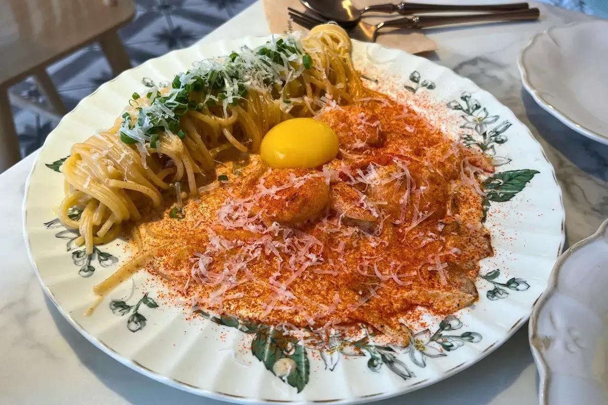 Spicy Cream Pasta garnished with cheese and fresh herbs, a savory and flavorful pasta dish at Sungsu Darak, Seongsu, Seoul.