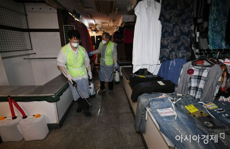 南大門市場清潔與消毒作業進行中，可見防疫人員正在一間店內進行消毒以防止COVID-19蔓延。