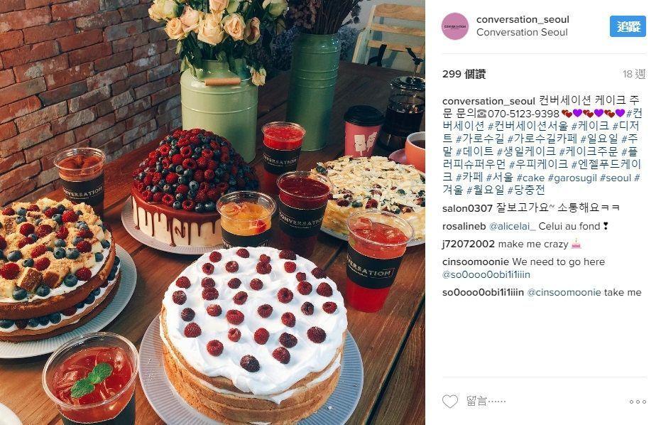 多款水果塔和草莓蛋糕的組合展示，圓形的甜點桌上環繞著鮮艷的花朵，帶來豐富的視覺享受。