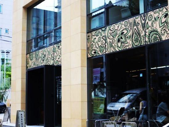 OUR Bakery咖啡店的外部圖像，大落地窗讓陽光充足照射進店內，外牆打印了圖案，吸引過往客人。