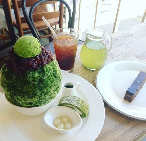 桌上擺滿了各種甜品，蛋糕、雪冰和飲料交錯擺放，營造出夢幻般的甜品盛宴。