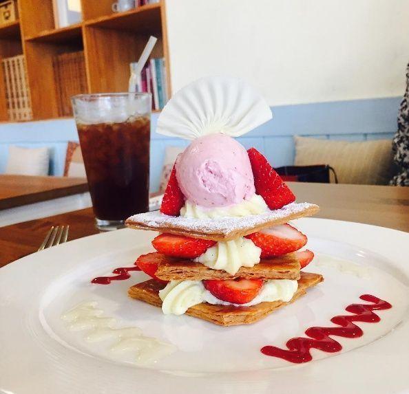 一個高聳的抹茶冰品周圍擺放著不同的飲料，讓人垂涎欲滴，充滿夏日清涼和愉悅。