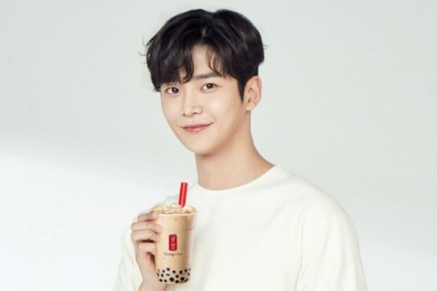 貢茶品牌海報，展示一位穿著白色上衣的人拿著一杯珍珠奶茶，表現出貢茶品牌的茶飲品系列的風味和文化。