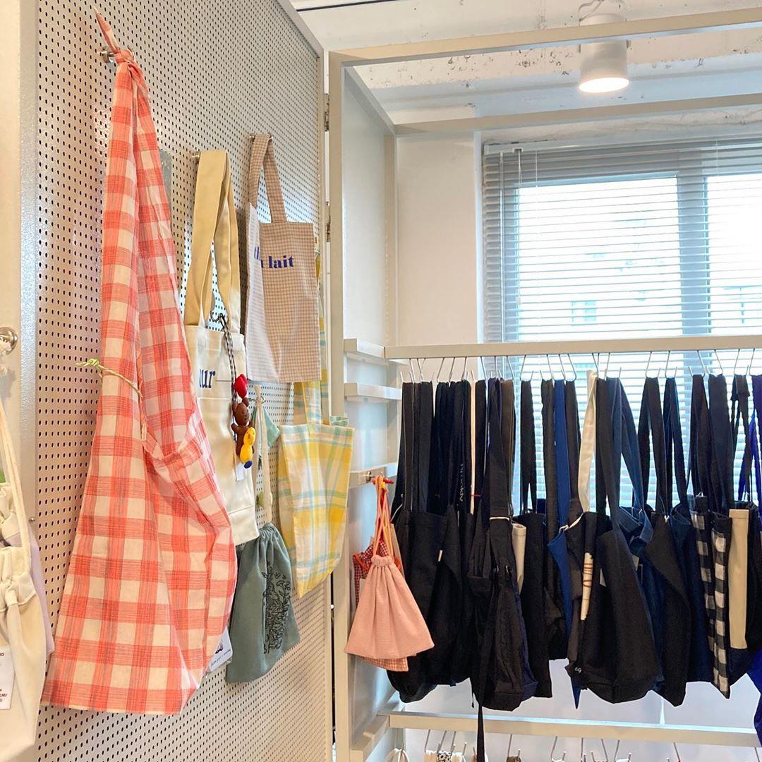 韓国雑貨店の店内に並べられた多様なバッグたちがディスプレイされている様子。カラフルで様々なデザインのトートバッグ。