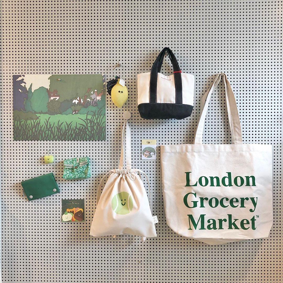 韓国雑貨店の壁にディスプレイされた様々なデザインのバッグとキャラクターグッズ。カラフルで可愛いアイテムがいっぱいです。