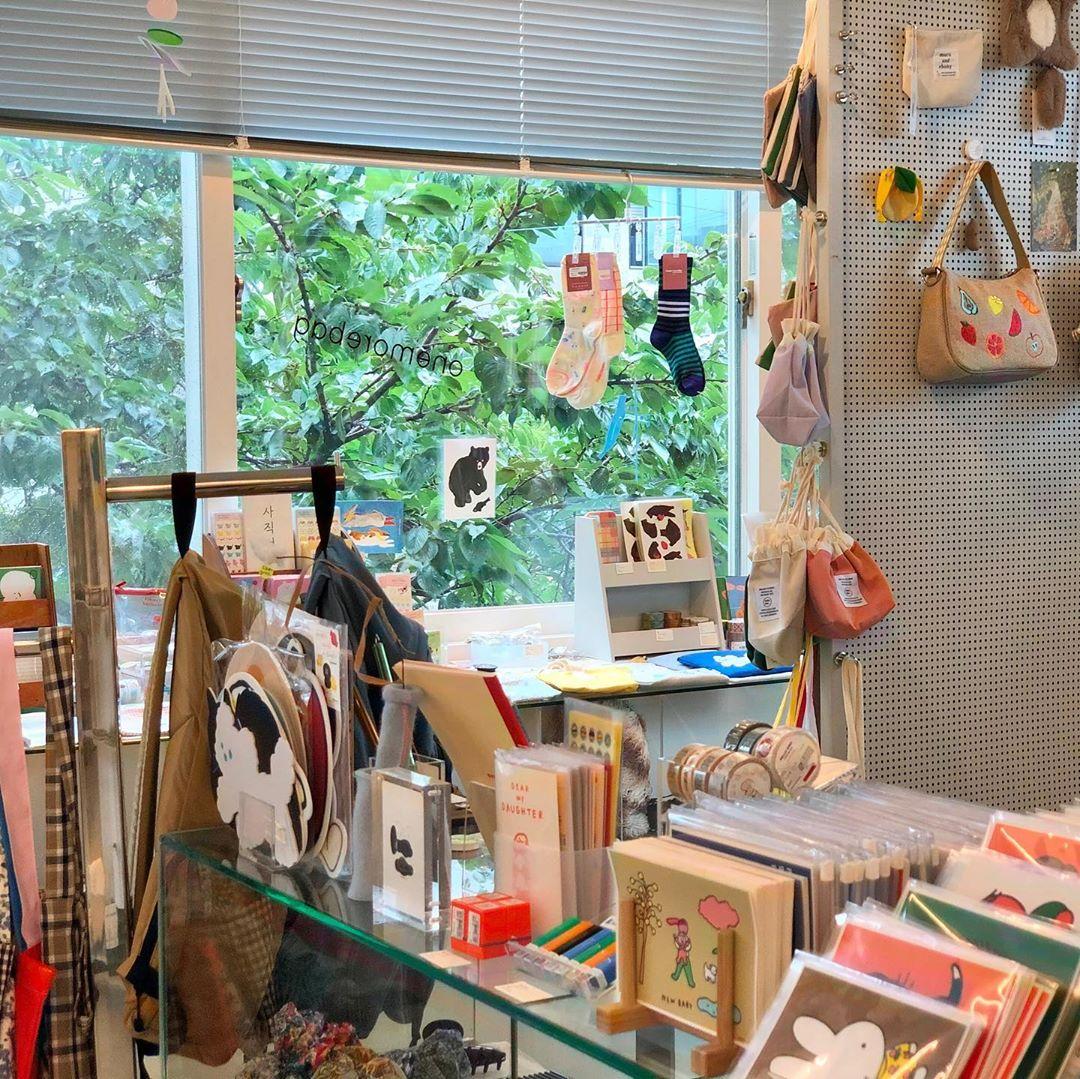 カラフルなキーホルダーが壁にディスプレイされた韓国雑貨店の一角。可愛いキャラクターやユニークなデザインのアイテムが並ぶ。