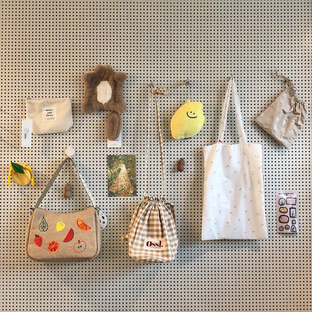 多様なデザインのバッグとポーチが壁にディスプレイされている様子。韓国雑貨店で販売されている可愛いアイテムたち。